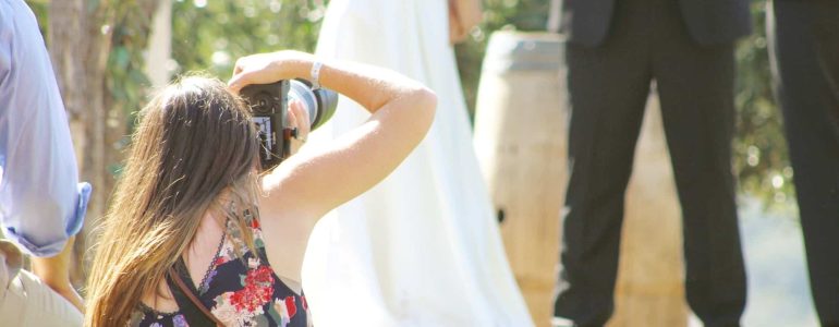 A wedding photographer is taking a picture of a wedding ceremony.