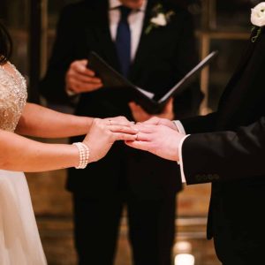 couple at their wedding ceremony, standing at the altar, exchanging rings