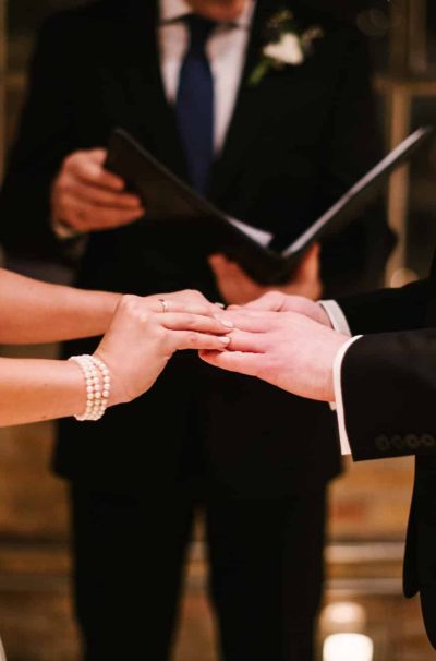 couple at their wedding ceremony, standing at the altar, exchanging rings