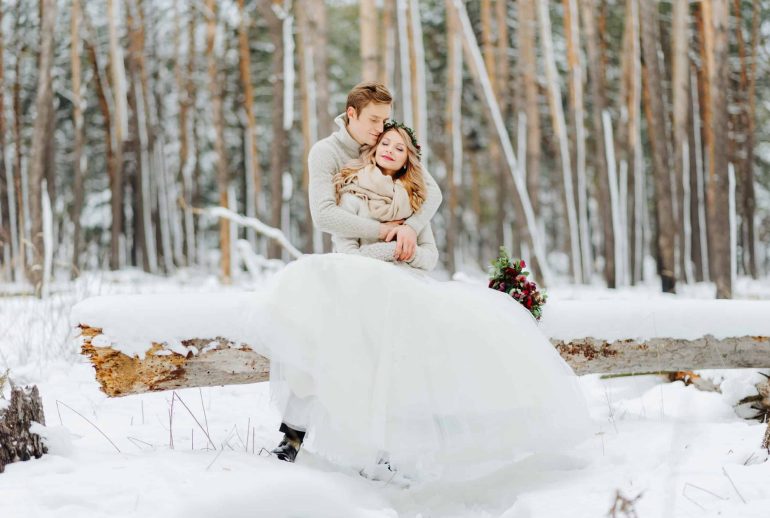 Winter wedding photosession in nature Couple in love are hugging on background of the snowy forest. Winter wedding.